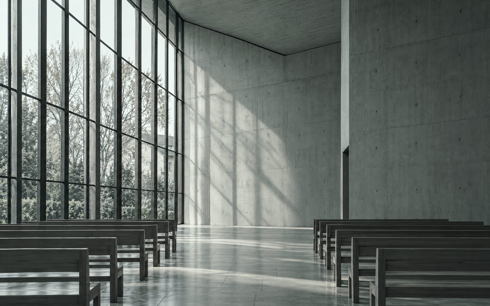 Eine hohe Glaswand einer modernen Kirche, durch die weiches Tageslicht auf eine helle Betonwand fällt.